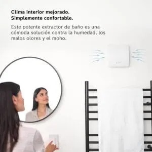 Mujer en el baño con un ventilador de pared instalado sobre el secatoallas, asegurando una ventilación eficiente y eliminando la humedad.